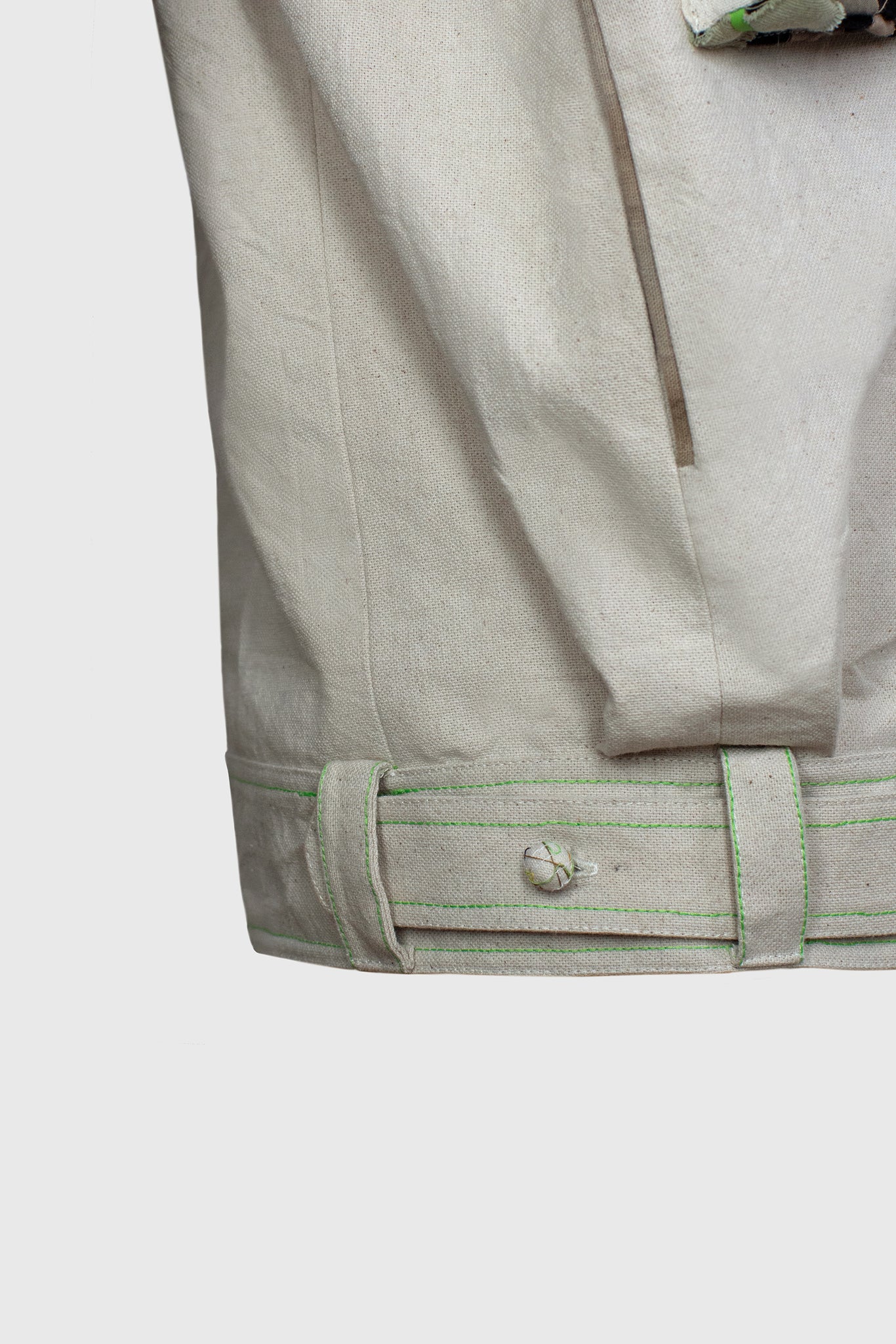 detail of a Fench seam on side pocket, bomber jacket with belt around waist, high end well made fashion