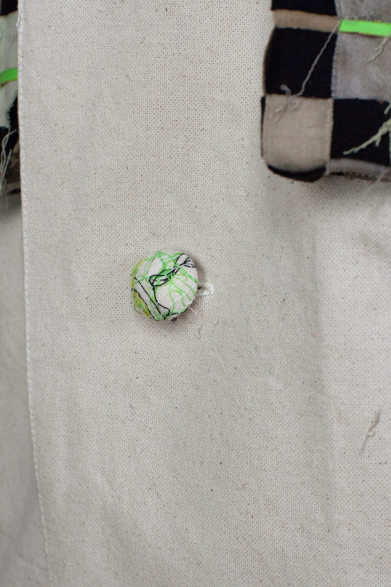 cotton covered button, with multicolor threads, neon green and black to contrast, well finished tailored sports jacket, fashion interpretation of a football jacket